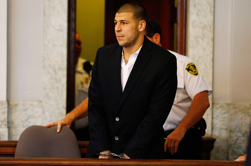 NORTH ATTLEBORO, MA - AUGUST 22: Aaron Hernandez is escorted into the courtroom of the Attleboro District Court for his hearing on August 22, 2013 in North Attleboro, Massachusetts. Former New England Patriot Aaron Hernandez has been indicted on a first-degree murder charge for the death of Odin Lloyd.